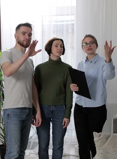 Female real estate agent showing modern apartment to young caucasian family buying new apartment. Real estate concept